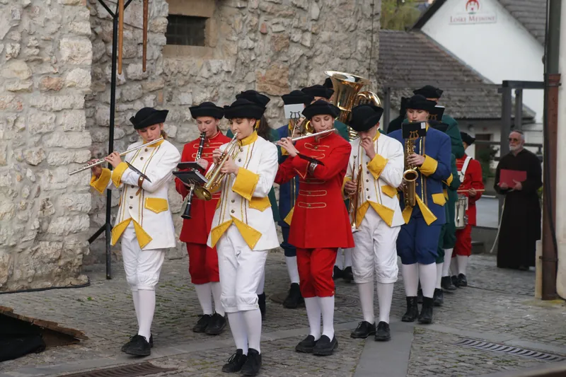 Pasijonska procesija z igralci in glasbeniki v baročnih kostumih